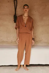 Chaqueta corta de escote en pico con cierre frontal de un botón. Presenta mangas cortas con detalle de vuelta, trabilla y botón, además de falsos bolsillos delanteros con solapa.