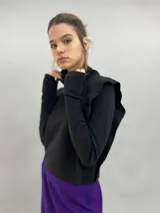 Buzo de jersey de lana color negro, con cuello elevado, hombreras estructuradas y mangas largas con puños con ojal para el pulgar.