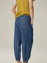 Pantalón de corte relajado color marrón, confeccionado en mezcla de algodón y lino. Presenta cintura con pasacintos, bolsillos laterales y diseño de botamanga ajustable con cordones y elástico.
