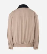 Campera de sarga color beige con corte oversized, cuello de cuero sintético negro con textura trenzada, cierre frontal oculto y bolsillos laterales.