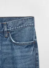 Jeans de corte recto y tiro medio, confeccionados en tejido denim de algodón. Presentan diseño clásico de cinco bolsillos, cierre frontal con cremallera y botón, y trabillas para cinturón.