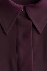 Vestido midi color bordó, con cuello camisero y tapeta con botones ocultos, de manga larga con puños anchos abotonados y corte holgado.