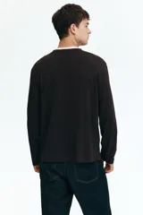 Remera de manga larga color marrón oscuro, con cuello redondo acanalado y corte recto.