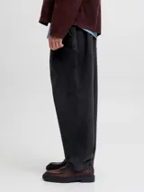 Pantalón gris oscuro de corte holgado, con pinzas en la cintura y estilo relaxed.