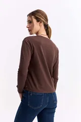 Remera de manga larga en color beige, con cuello redondo y corte recto, confeccionada en algodón.