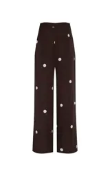 Pantalón de vestir marrón con estampado de lunares blancos, de tiro alto y corte ancho.