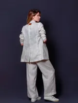 Blazer de lino color blanco, de corte recto y doble botonadura con botones color beige.