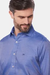 Camisa de manga larga color azul con micropadrón geométrico, cuello camisero clásico y cierre frontal con botones.