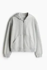 Campera con capucha y cierre frontal, color gris melange, confeccionada en felpa con interior cepillado suave. Presenta hombros caídos, bolsillos canguro y puños y bajo en punto acanalado.