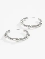 Par de aros tipo argolla de acero quirúrgico hipoalergénico color plateado, con tres bolitas decorativas. Cierre con pasante.