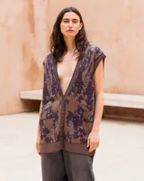 Chaleco oversize de punto con hilo lúrex, cuello en V y cierre frontal de botones. Presenta un estampado jacquard con efecto marmolado en tonos marrones y morados, bolsillos frontales aplicados y ribetes en contraste en el escote, sisas y dobladillo.