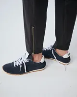 Pantalón negro de corte slim, confeccionado en lana y poliéster con elastano. Presenta cintura elastizada, cierre frontal con snap metálico, bolsillos laterales con cierre metálico y cierre en la botamanga.