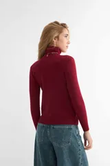 Polera de cuello alto y manga larga, confeccionada en tejido de punto fino con puños y ruedo acanalados.