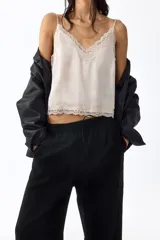 Pantalón de corte holgado en tejido liviano de mezcla de lino, con tiro alto, cintura elástica y cordón ajustable, bolsillos laterales y piernas rectas.