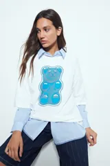 Remerón de manga corta con calce amplio y estética urbana, confeccionado con proceso de lavado que le otorga un efecto desgastado. Presenta una estampa gráfica frontal de un oso de goma en color verde.