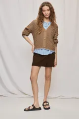 Cardigan de punto calado color tostado, con escote en V y cierre frontal de botones.