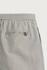 Short de baño confeccionado en tejido técnico con patrón de rayas verticales en tonos azul marino y blanco, con cintura elástica ajustable mediante cordón y bolsillos laterales.