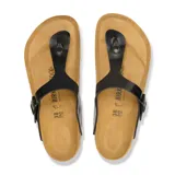 Sandalia Birkenstock modelo Gizeh, color negro charol, con tira de dedo y hebilla ajustable.