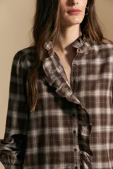 Camisa de algodón a cuadros con diseño de volados frontales, cuello alto y mangas largas con leve volumen.