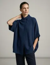 Capa tejida color fucsia, con cuello alto abotonado y mangas cortas estilo japonesa. Tejido de punto grueso.