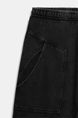 Pantalón de algodón negro con tiro medio, cintura elástica, pierna recta y grandes bolsillos laterales aplicados.