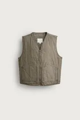 Chaleco de algodón acolchado de corte relaxed fit, color verde militar con efecto lavado. Presenta cuello en V, cierre frontal con cremallera y bolsillos frontales de parche.