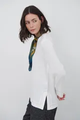 Blusa azul marino de corte recto y holgado, con escote en V y mangas largas. Presenta detalles de costuras a la vista en color blanco en el escote, puños y ruedo.