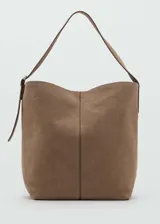 Bolso tipo hobo de gran tamaño confeccionado en piel de serraje color marrón, con asa de hombro ajustable mediante hebilla metálica y cierre interior de imán.