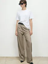 Pantalón de vestir de corte sastrero, con diseño de pierna ancha y tiro alto. Presenta pinzas frontales, cierre con cremallera y botón oculto, además de trabillas para cinturón.