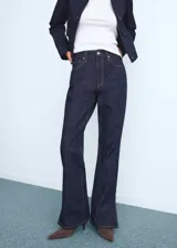 Jeans de corte recto y tiro medio, confeccionados en tejido de algodón estilo vaquero en tono azul oscuro. Presentan diseño de cinco bolsillos, cierre de botón con cremallera, trabillas para cinturón y aberturas laterales en el bajo.