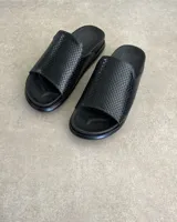 Sandalias chatas de cuero vacuno color negro con diseño de escamas.