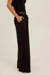 Pantalón de punto acanalado negro de tiro alto, pierna recta y relajada, con cintura elástica y cordón ajustable, y bolsillos laterales.