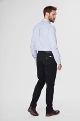 Pantalón de gabardina color marrón claro, corte slim fit, con bolsillos laterales y traseros. Se ajusta a la cintura con cinturón de cuero marrón.