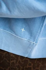 Buzo lila oversize confeccionado en 100% algodón, con cuello redondo, mangas largas y puños y dobladillo acanalados. Presenta un pequeño detalle bordado en el bajo.