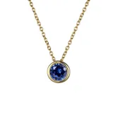 Collar de cadena fina con dije de punto de luz circular que contiene una circonita verde engastada en acero quirúrgico con baño de oro.
