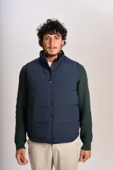 Chaleco tipo puffer color azul marino, con cierre frontal completo, cuello alto y logo bordado en el pecho.