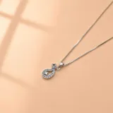 Conjunto de collar y dije de plata con baño de rodio, decorado con circonias brillantes. El dije tiene forma de gota estilizada con una piedra central destacada.