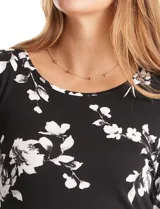 Remera de modal estampada con flores blancas sobre fondo negro, de manga larga y cuello redondo.