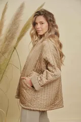 Campera tipo kimono acolchada en color azul petróleo, con diseño de costuras verticales y bolsillos frontales amplios. Presenta mangas largas con puños vueltos y un corte holgado y abierto.