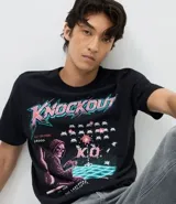 Remera de algodón color negro con cuello redondo y manga corta. Presenta un estampado frontal con temática de videojuegos retro que incluye una figura de la muerte, elementos gráficos y la palabra Knockout.