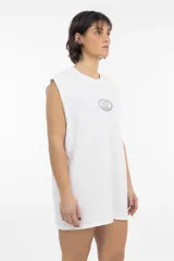 Musculosa blanca de corte recto y holgado, con cuello redondo y sisas amplias. Presenta un pequeño logo bordado en el centro del pecho dentro de una forma ovalada.