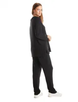 Buzo de calce suelto y relajado confeccionado en tejido soft, con cuello a la base y escote en V. Presenta mangas largas con puños.