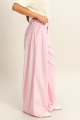 Pantalón de vestir color rosa claro, tiro alto, con pliegues frontales y pierna muy ancha.