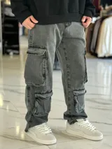Pantalón de jean estilo cargo, color azul, de corte ancho y holgado, con múltiples bolsillos laterales en muslos y pantorrillas.