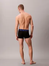 Pack de tres bóxers trunk Calvin Klein de microfibra negra con cintura elástica con el logo de la marca en azul, gris y blanco.