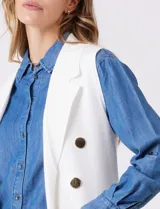 Chaleco largo tejido color blanco de la marca Sioni, con cuello solapa, doble botonadura dorada en el frente y bolsillos aplicados.