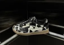 Zapatillas bajas de cuero con estampado de vaca en blanco y marrón.