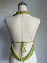 Conjunto de dos piezas color verde oliva, compuesto por un top con escote profundo y diseño cruzado, y una falda midi ajustada de tiro alto.