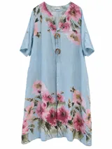 Vestido midi celeste con estampado floral en tonos rosados y verdes, escote en V con botones decorativos de madera y cordones, y mangas cortas.