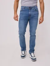 Jean de corte slim fit con cintura media y cierre frontal con botón y cremallera. Presenta un lavado azul clásico con costuras en contraste.